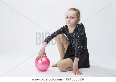 Caucasian Female Rhythmic Gymnast In Professional Competitive Black Sparkling Suit Posing With Ball in Studio On White.Horizontal Image
