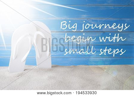 English Quote Big Journey Begin With Small Steps. Sunny Summer Greeting Card With Sand And Flip Flops. Blue Vintage And Shabby Chic Wooden Background.
