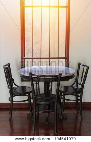 Wooden round table and chair chiness style near window have ray of light on wood floor and white wall