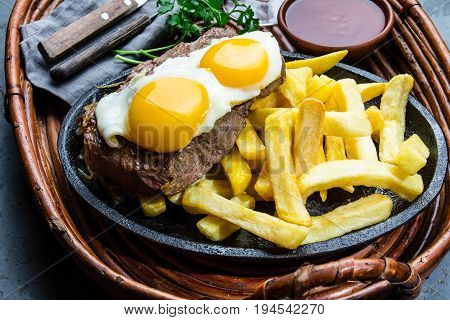 Peruvian Latin American food. Lomo a lo pobre. Beef whit fried potatoes french fry and egg served with chile sauce and wine