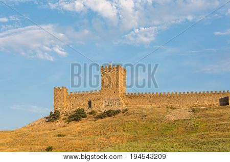 Krym Sudak ruins of an old fortress on a green hill with a piece of gear stone walls. Genoese fortress