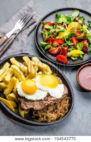 Peruvian Latin American food. Lomo a lo pobre. Beef whit fried potatoes french fry and eggs