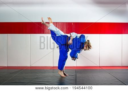 Two young women fight judo on tatami
