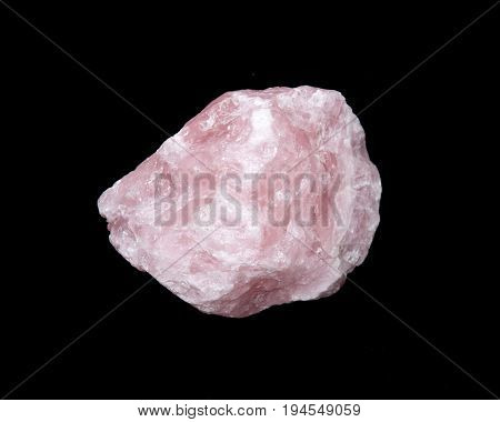 Raw rose quartz from Madagascar isolated on black background