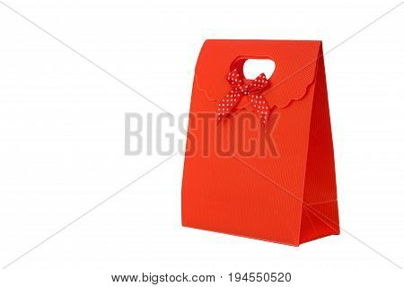 Bright red gift bag with red and white spotted bow isolated on white background