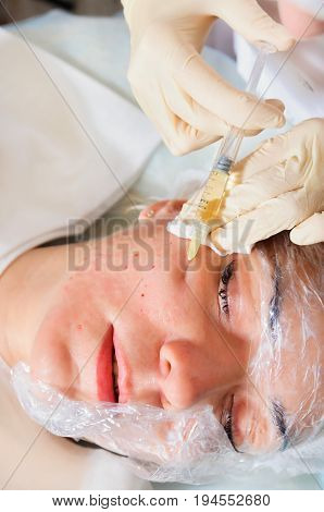 Dermatologist injections of mesotherapy in the face of the patient.