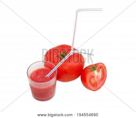 Big fresh whole tomato with bendable drinking straw inserted into it half of the tomato and glass with tomato juice with drinking straw on a light background