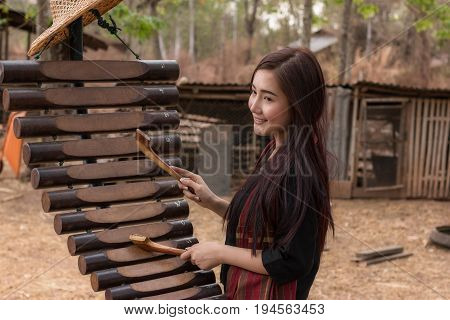 The lifestyle of rural girl playing Pong lang at countryside.