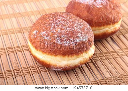 Homemade Doughnuts with Jelly filled and powdered sugar on Bamboo tablecloth. Selective focus