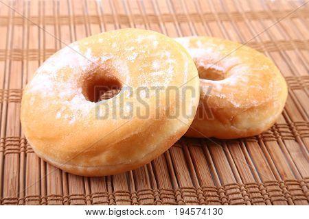Homemade Doughnuts with Jelly filled and powdered sugar on Bamboo tablecloth. Selective focus