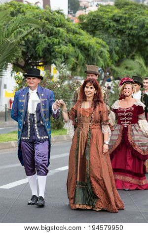 FUNCHAL MADEIRA PORTUGAL - SEPTEMBER 4 2016: Group of people in historical fashion dress durnig historical and ethnographic parade of Madeira Wine Festival in Funchal. Madeira Portugal