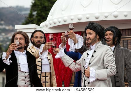 FUNCHAL MADEIRA PORTUGAL - SEPTEMBER 4 2016: Men in historical fashion dress raise toasts durnig historical and ethnographic parade of Madeira Wine Festival in Funchal. Madeira Portugal