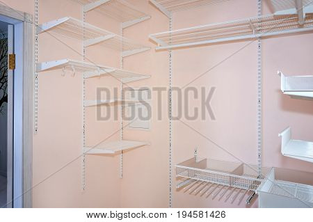 Empty walk-in closet with shelves. Dressing room Interior elements