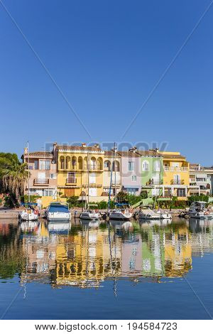 VALENCIA, SPAIN - JUNE 13, 2017: Colorful houses with reflection in the water of Port Saplaya in Valencia, Spain