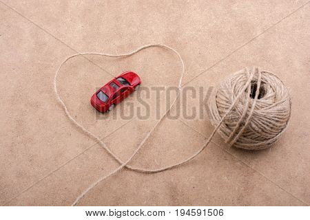 Red Toy Car And A Spool Of Thread Form A Heart Shape