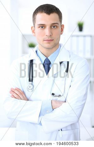 Friendly male doctor in the hospital office. Ready to examine and help patients. High level and quality medical service concept. Best treatment and patient care concept
