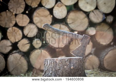 A Deck Of Stacked Logs And An Axe