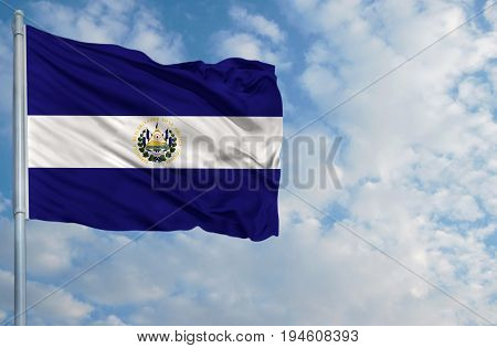 National flag of El Salvador on a flagpole in front of blue sky.