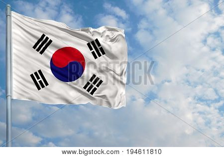 National flag of South Korea on a flagpole in front of blue sky.