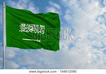 National flag of Saudi Arabia on a flagpole in front of blue sky.