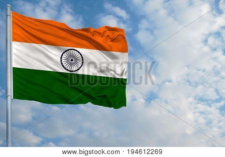 National flag of India on a flagpole in front of blue sky.