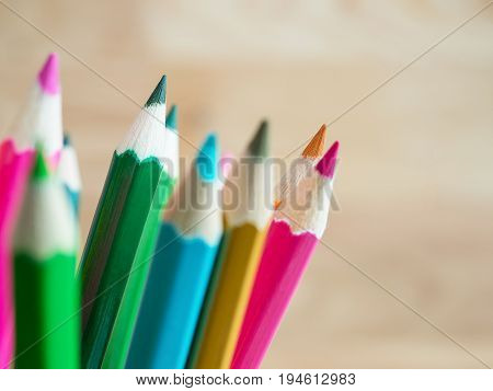 Closeup stack of color pencils in verious color with wood blur background (Selective Focus)