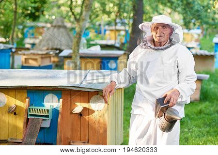 Horizontal shot of a senior male beekeeper standing in the garden at his apiary copyspace.
