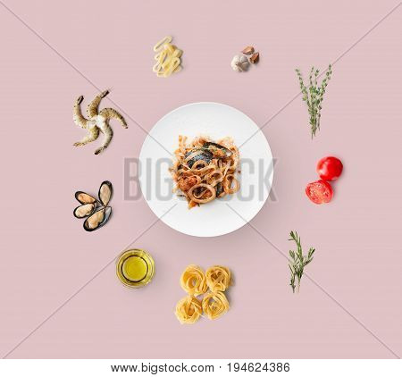 Cooking ingredients for italian food, seafood pasta, isolated on pink. Frutti di mare with fettuccine spaghetti. Mussels, prawn, shrimp, calamari rings and other ingredients around plate with dish