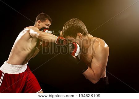Two professional boxer boxing on black studio background.