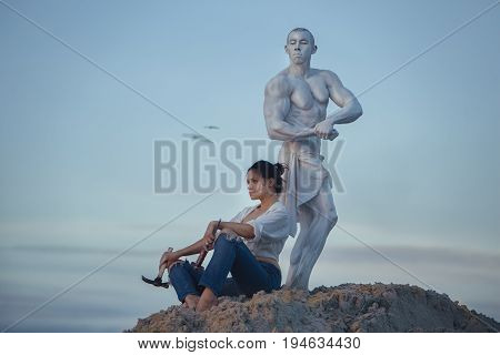 Woman has created a sculpture of a man and has a rest.