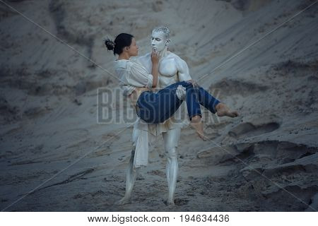 Sculpture of a man holds a woman in his arms they are in love.