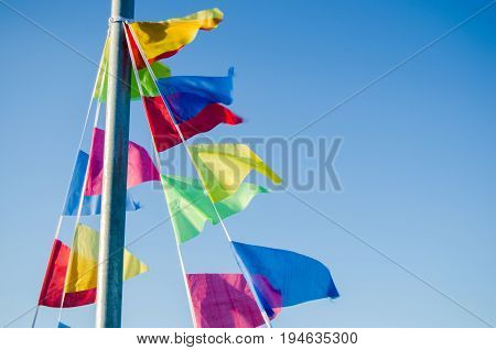 Dangling in the wind festive flags on the background of blue sky