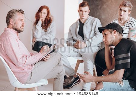 Insightful therapist talking to a troubled teenager psychotherapy concept