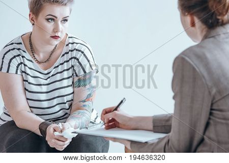Girl holding a tissue while listening to her counselor