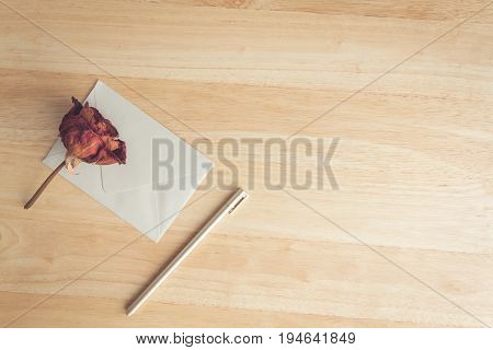 letter and pen with dry rose on wood table for background