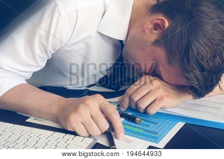 Chronic fatigue syndrome concept. Overworked businessman is sleeping at desk.