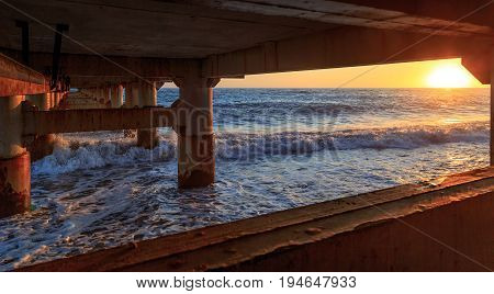 Waves smite upon the mooring support at sunset