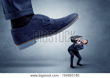 Big foot trying to crush small man who is afraid of that