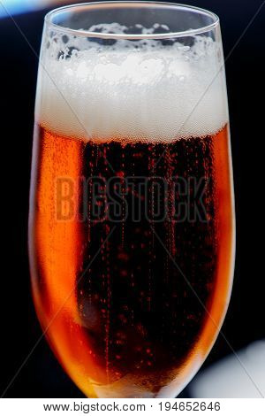 Glass of fresh beer with foam and bubbles