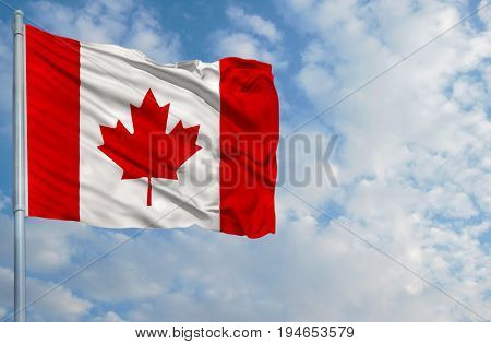 National flag of Canada on a flagpole in front of blue sky.
