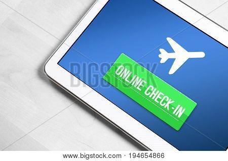 Online check in with tablet. Top view to mobile device on wooden table ready to checking in to flight on internet, web or application. Self service provided by airline.