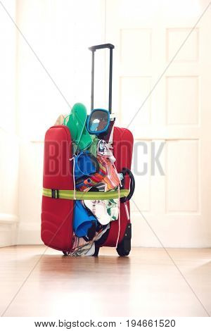 Overstuffed suitcase in hallway