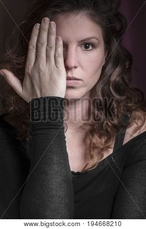 Woman with brown eyes keep one closed