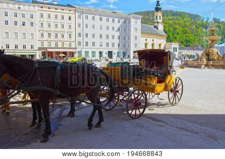 Salzburg, Austria - May 01, 2017: Central place in Salzburg city , Austria with carriages and horses at Salzburg, Austria on May 01, 2017