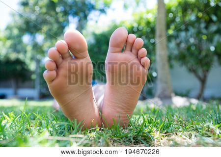 Low section of girl lying on grassy field in back yard