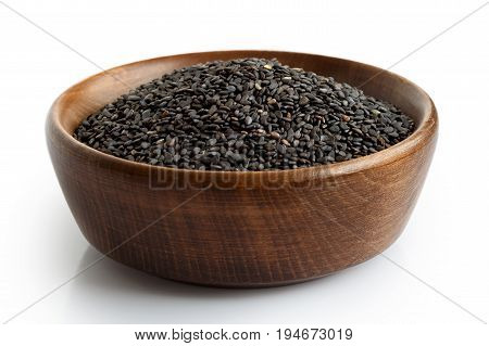 Black Sesame Seeds In Dark Wooden Bowl Isolated On White.