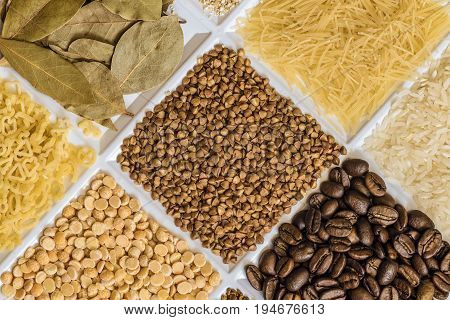 Buckwheat in set of groceries with bay leafs vermicelli rice roasted coffee beans dried peas figured macaroni.