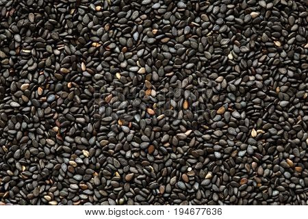 Dark background of black sesame seeds. Texture.