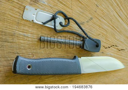 Tourist knife with flint. Knife and flint on wood background.