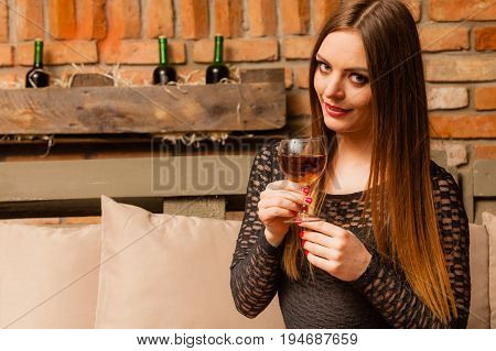Elegant beauty lady long hair full make up wearing black dress tasting wine in rural cottage interior celler